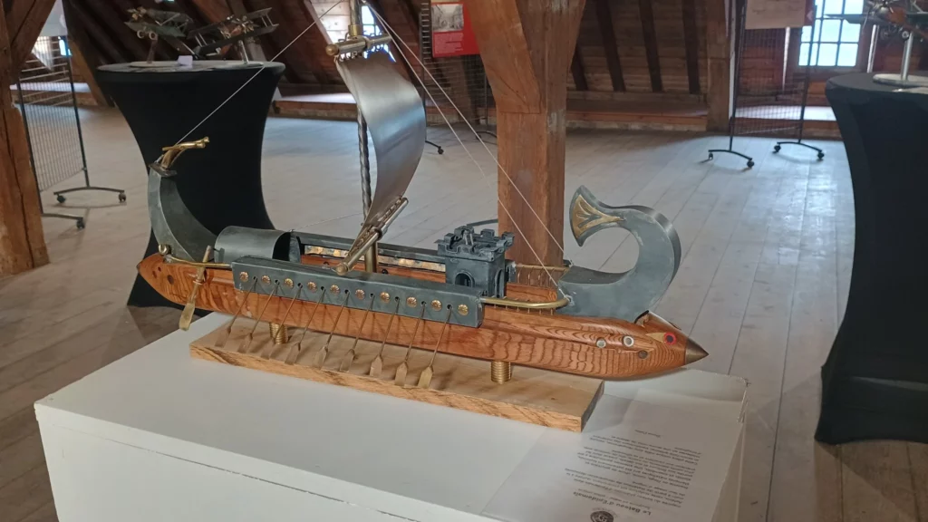 Sculpture de bateau à voile en métal présentée en exposition.